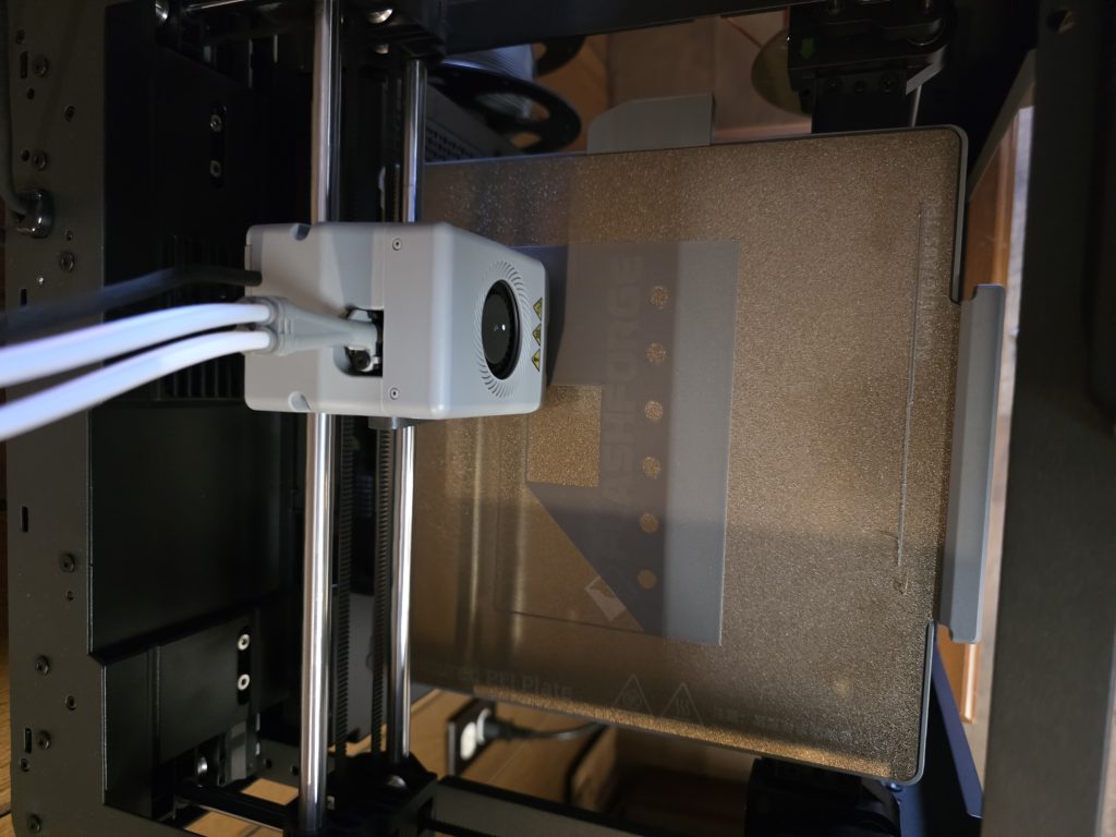 A 3D printer part-way through printing a faceplate.
