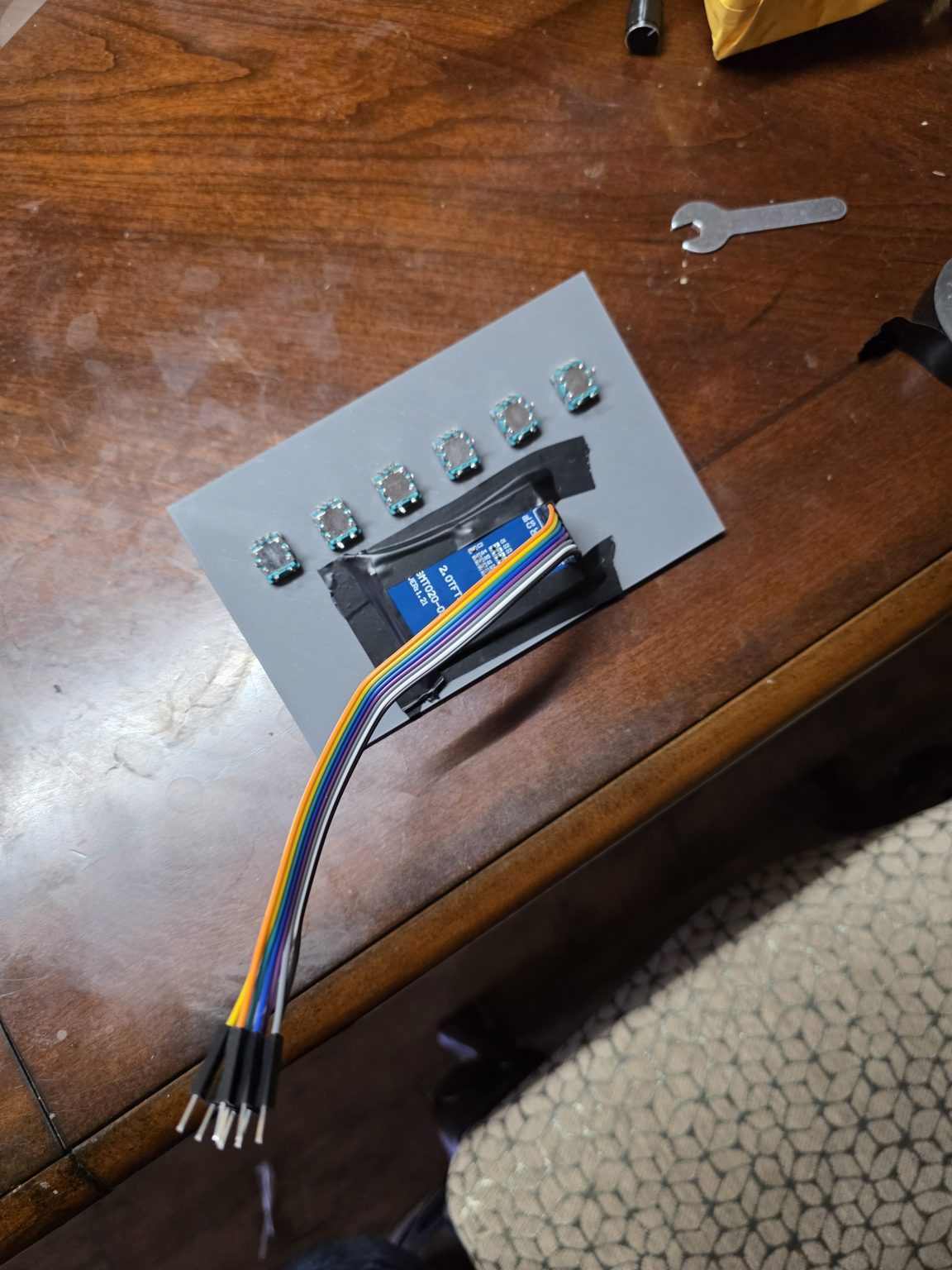 A 3D-printed faceplate with electrical tape holding the screen where standoffs should be.