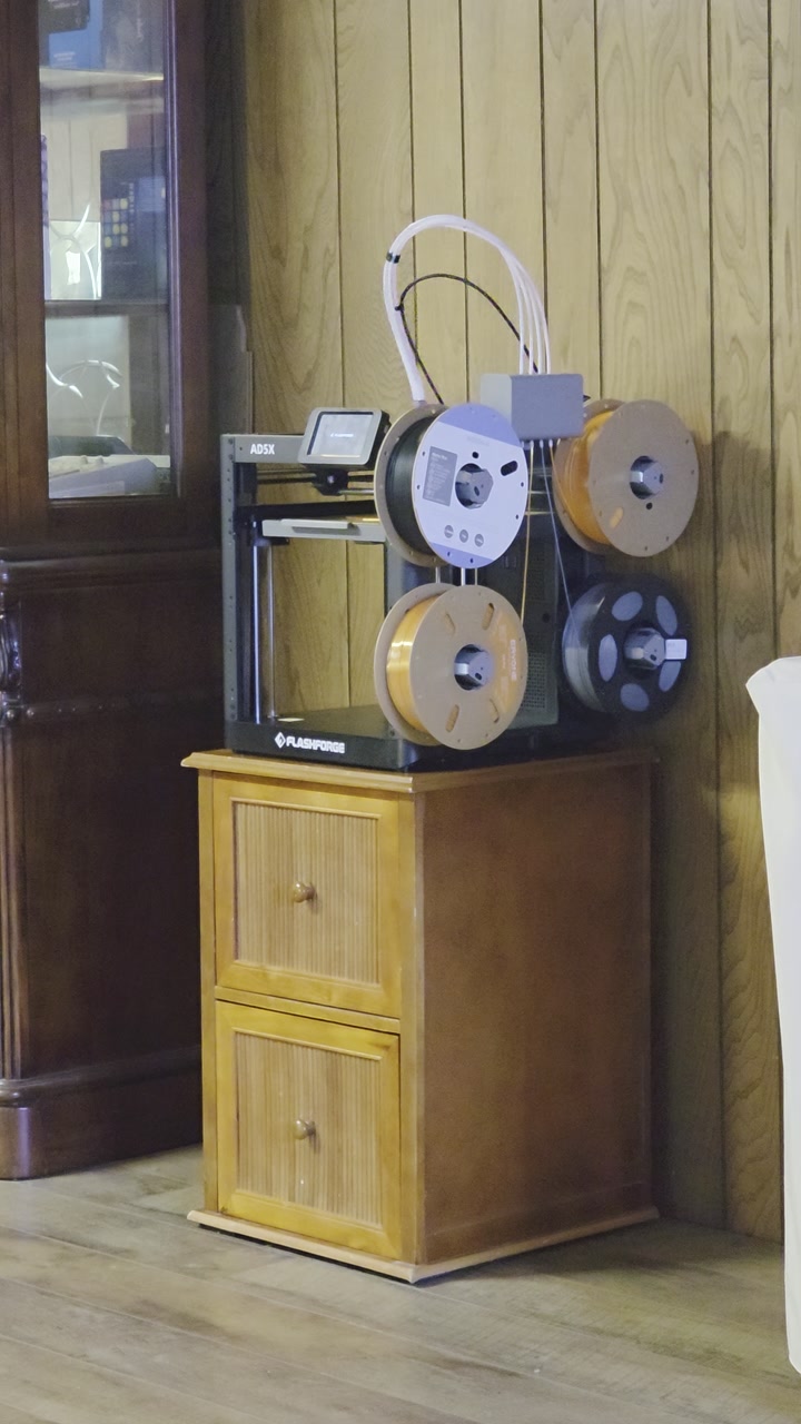 A still frame from a clip of a 3D printer running.